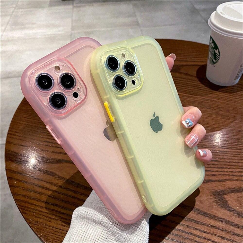 Coques antichocs en silicone jaune et rose pour iPhone 13 Pro Max posées sur une table en bois. - Wiqeo
