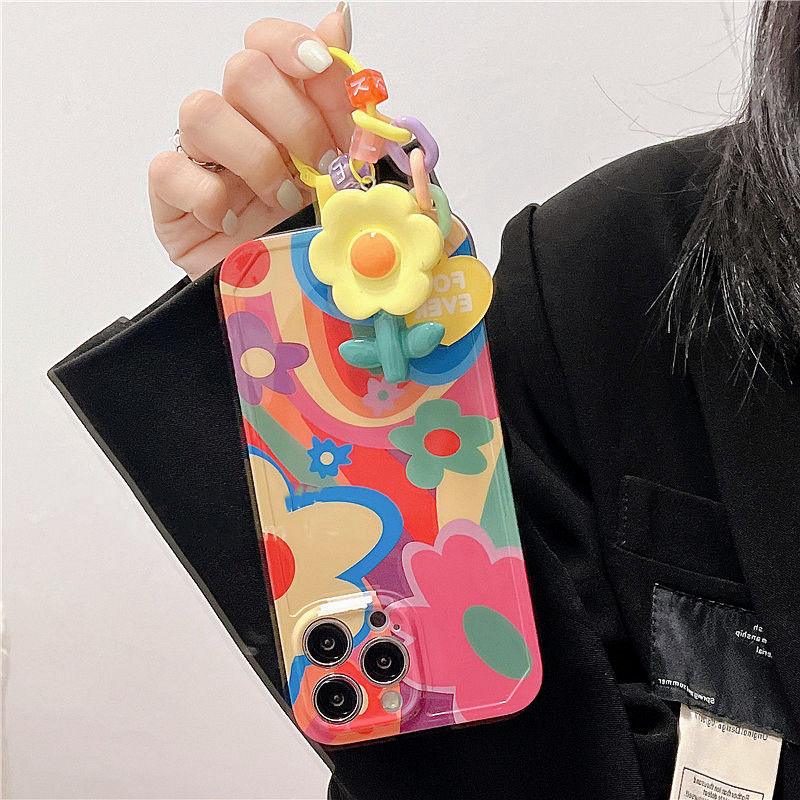 Coque iPhone 15 Plus colorée avec motif graffiti floral et porte-clés fleur jaune en silicone. - Wiqeo