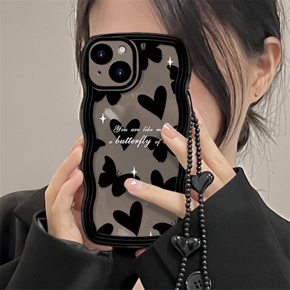 Coque iPhone 15 noire avec papillons et cœurs noirs, texte blanc, sangle à perles noire avec cœurs en relief. - Wiqeo